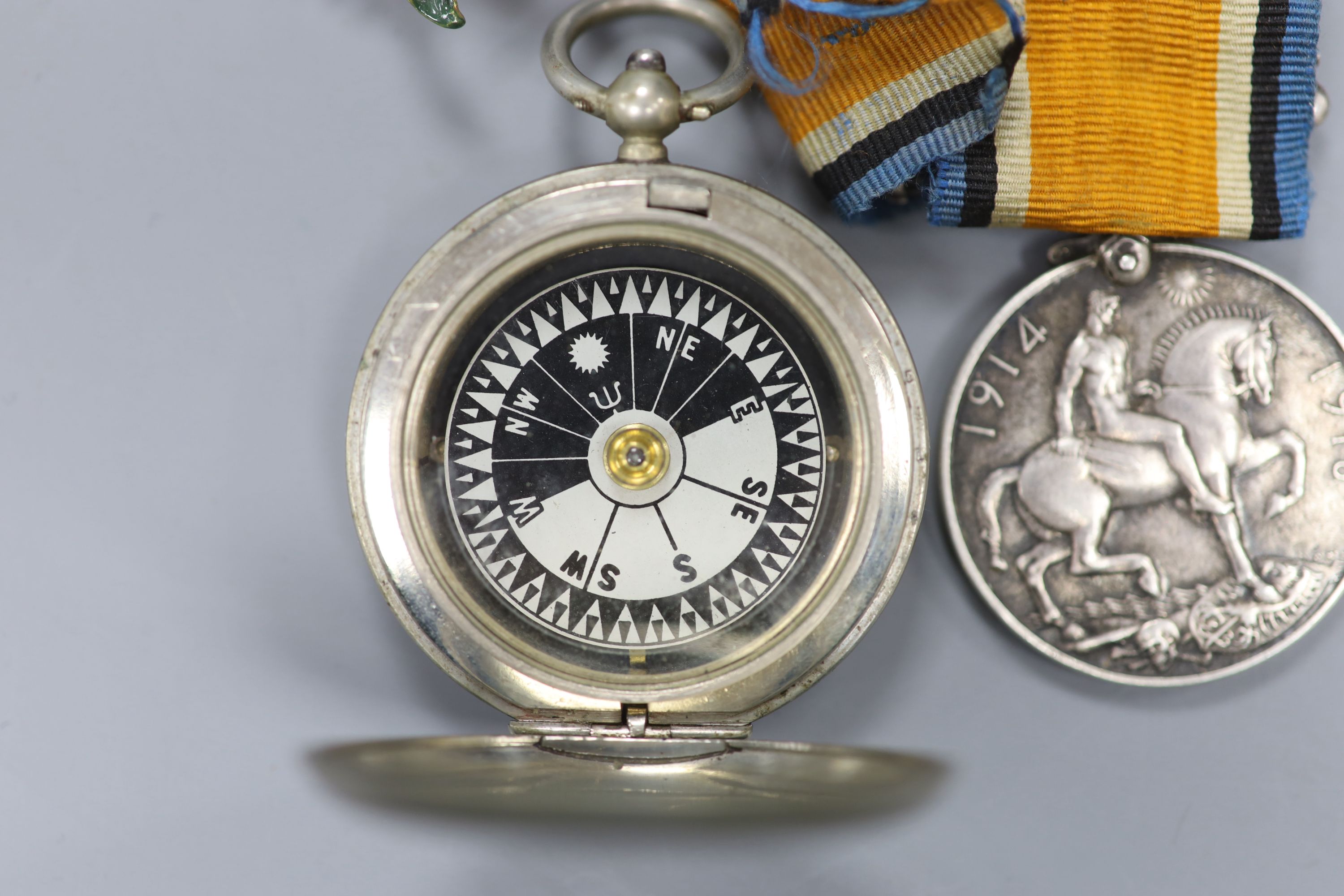 A WWI compass and two medals, together with lapel badges, etc.